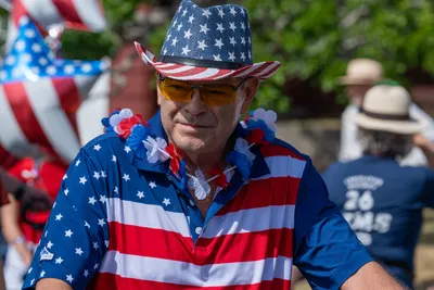 A man dressed head to toe in American flag attire watches the Fourth of July parade in Home, Washington.